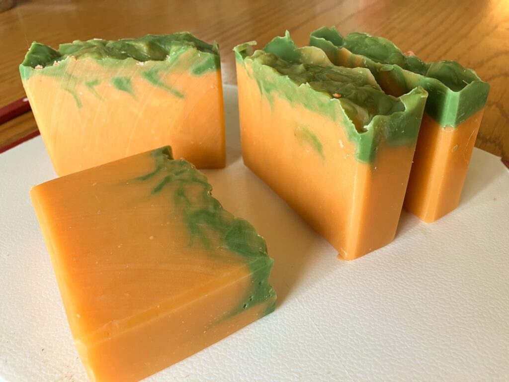 Four bars of orange so with a textured green top and green tendrils swirling into the orange.