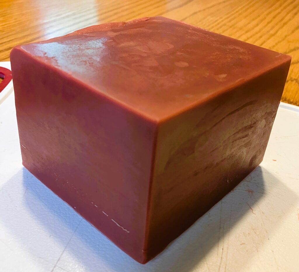 A small block of wine-red homemade soap.