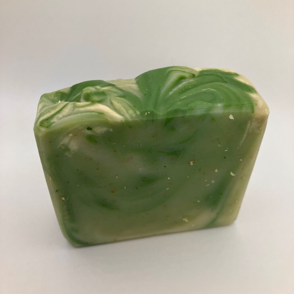 Bar of green and white swirled soap with scrubby texture.