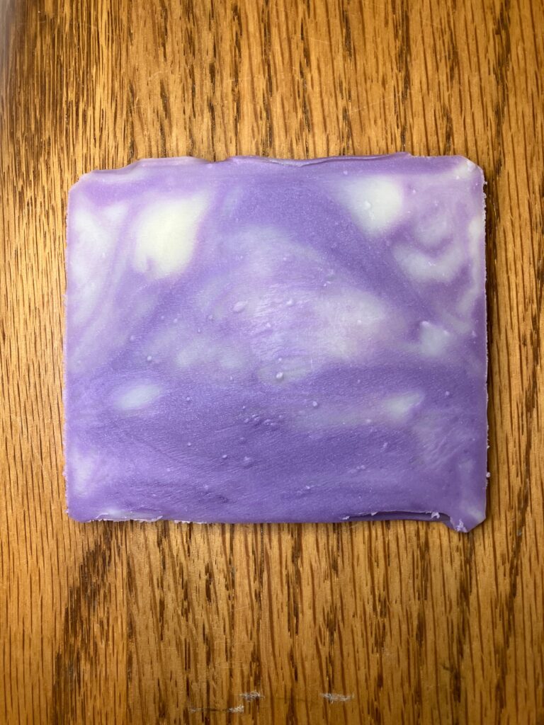 Bar end of purple and white swirled soap.
